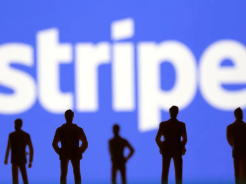 Silouettes of people standing infront of a Stripe logo