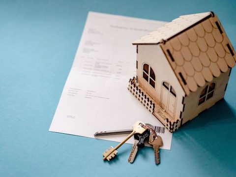 wooden house on top of legal documents