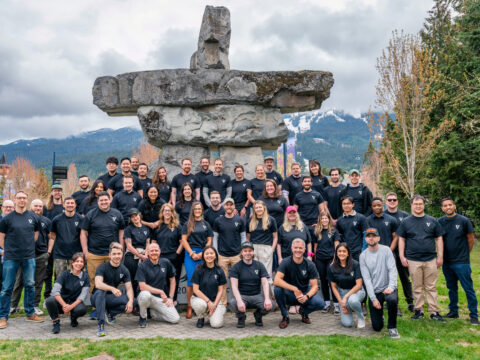 the VRIFY team in matching black t shirts with an inukshuk in the background