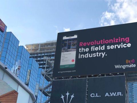 Toronto intersection with billboard for Wingmate that says revolutionizing the field service industry