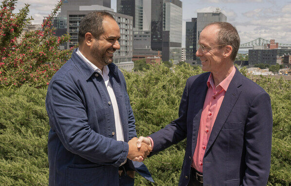 Cherif Habib CEO of Dialogue and Jacques Goulet President of Sun Life shake hands outdoors with the Montreal skyline in the background