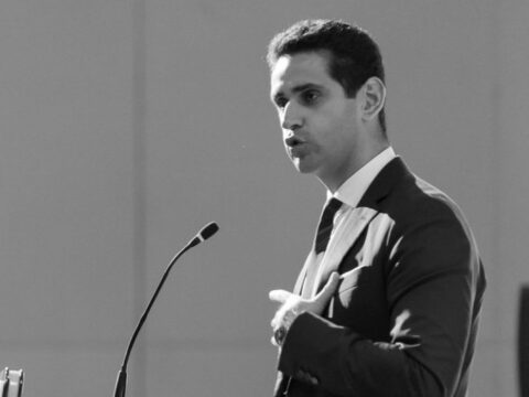 Abraham Tachjian, open banking lead, speaking in front of a microphone in a suit